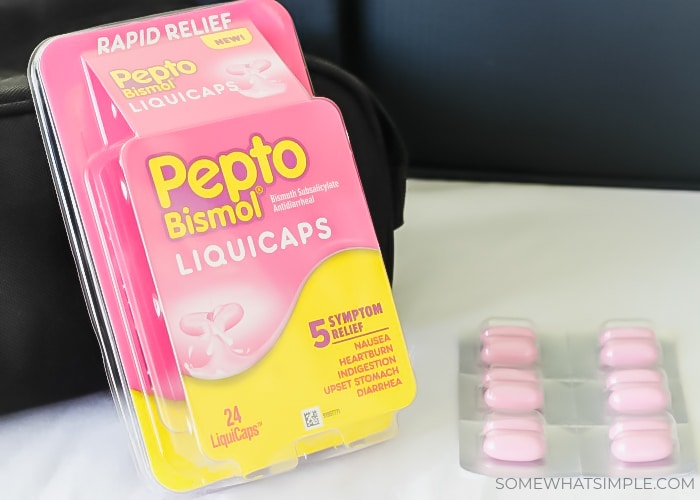 packing tips with a toiletry bag with a package of Pepto Bismol next to it