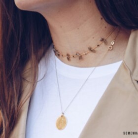 how to wear a necklace. pretty woman wearing a gold chain around her neck with a smaller necklace layered on top