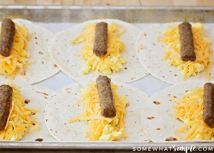 tortillas topped with eggs, cheese and sausage links