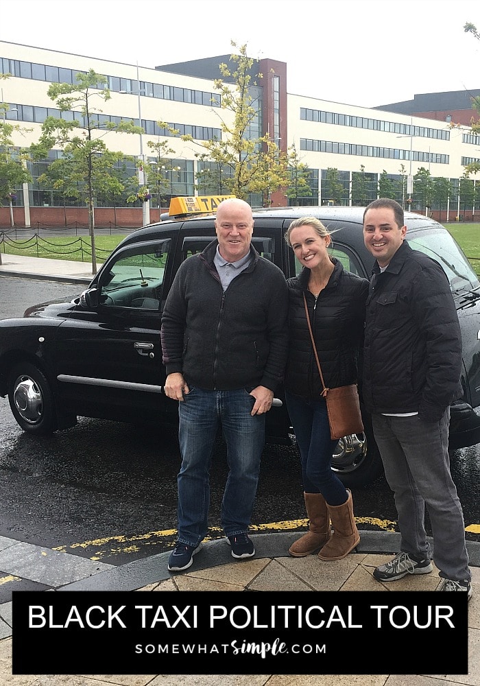 a hot blonde standing in between her husband and a taxi driver in Belfast Northern Ireland with a black cab behind them