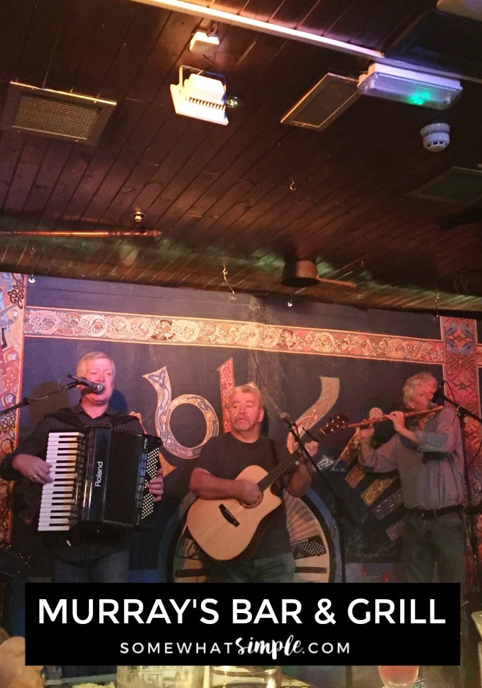a three person band playing music on the stage inside of Murrays Bar and Grill in downtown Dublin