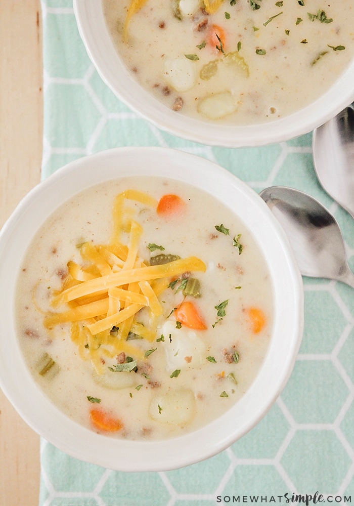 looking down on two bowls of crock pot cheeseburger soup in white bowls