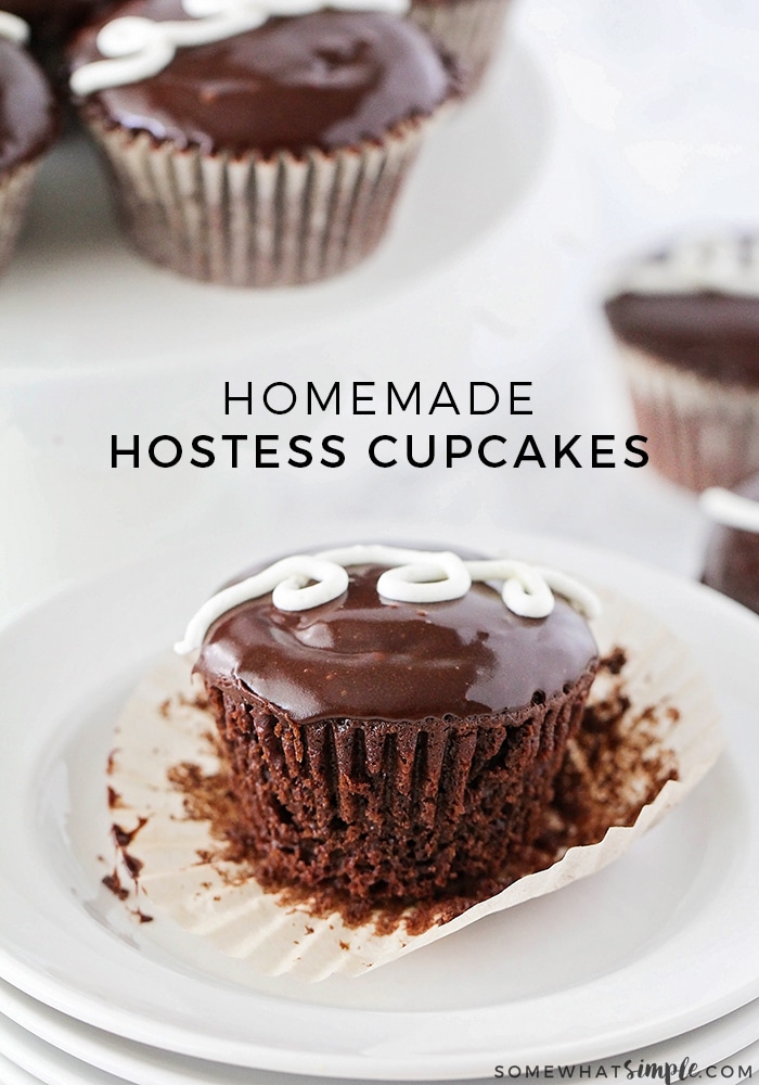 Homemade Hostess Cupcakes on a white plate. The chocolate cupcakes are topped with a swirl of white icing.