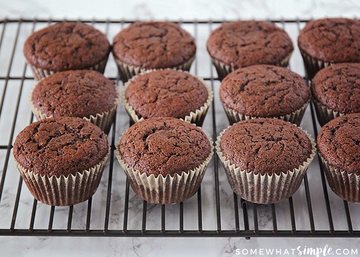 fluffy baked chocolate cupcakes sitting on a cooling rack made with this Homemade Hostess Cupcakes recipe