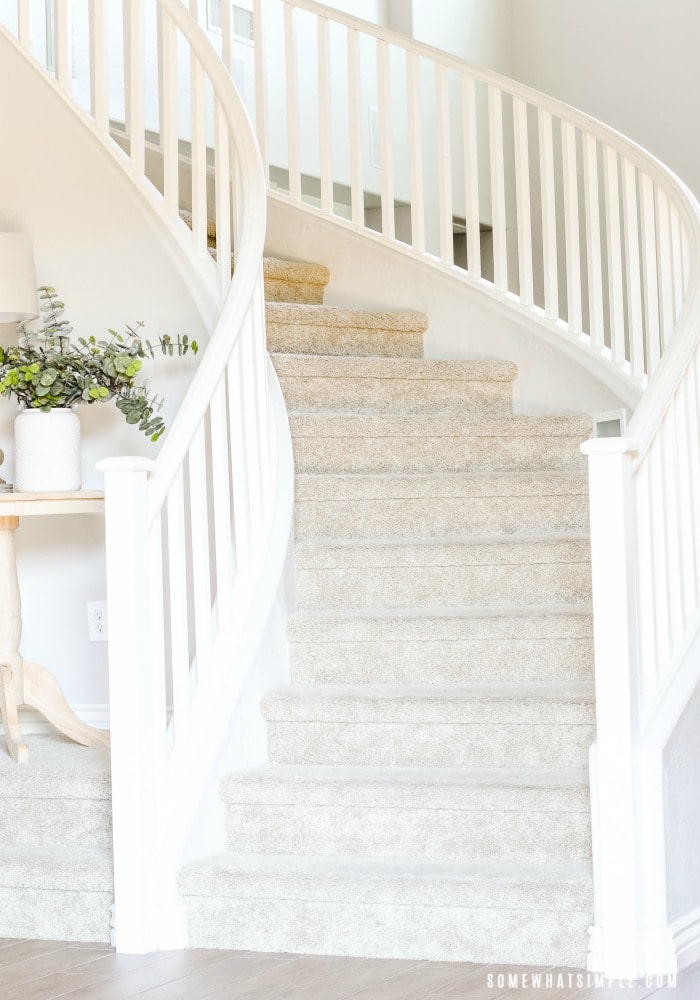 a winding staircase with a white wooden hand rail.