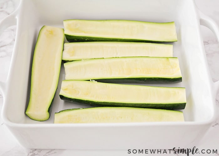 raw slices of zucchini in a baking pan