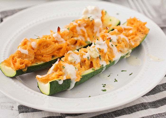 two buffalo chicken zucchini boats on a plate