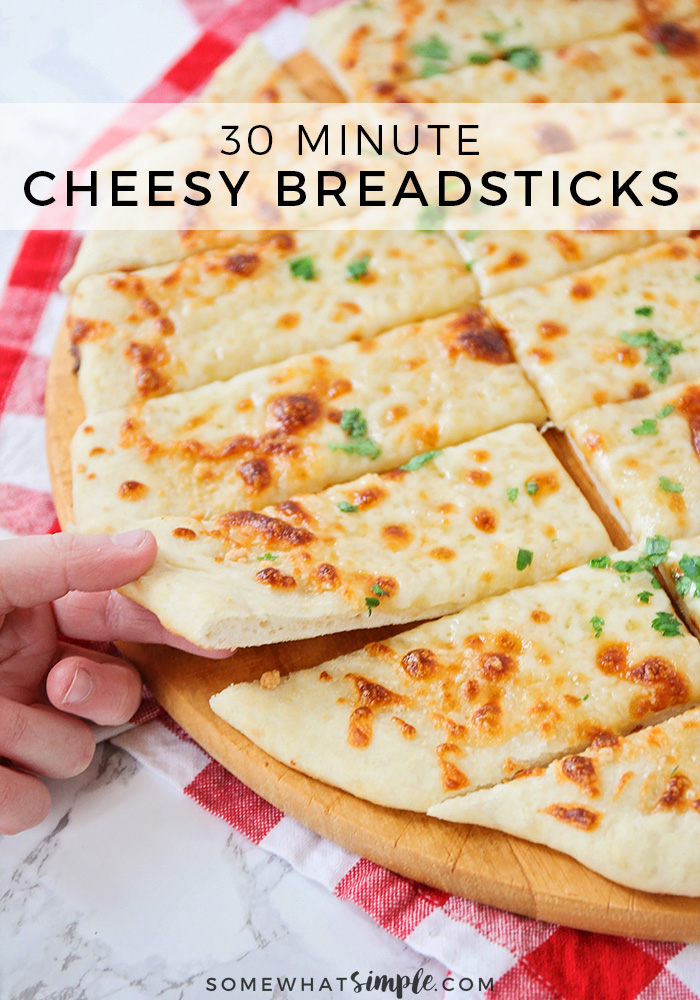 These cheesy breadsticks are so easy, they only take 30 minutes to make from start to finish. You can enjoy these homemade breadsticks as an appetizer or side dish and go great with any meal. #cheesebreadsticks #homemadecheesebreadsticks #cheesybreadsticks #easybreadrecipe #cheesebreadsticksrecipe via @somewhatsimple