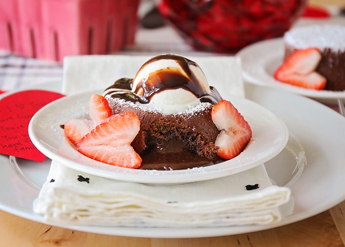 a chocolate lava cake with heart-shaped strawberries