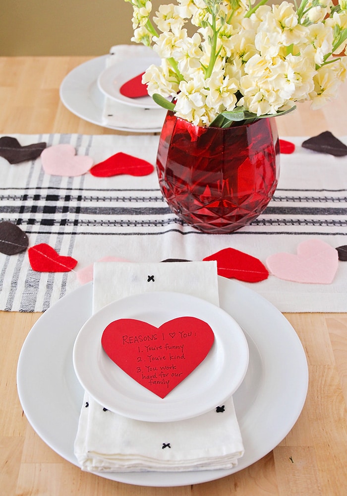 a valentine place setting with a paper heart note on the plate
