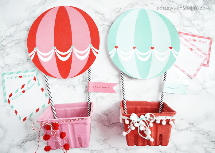 Two hot air balloon Valentine boxes. One is red and the other is a light blue.