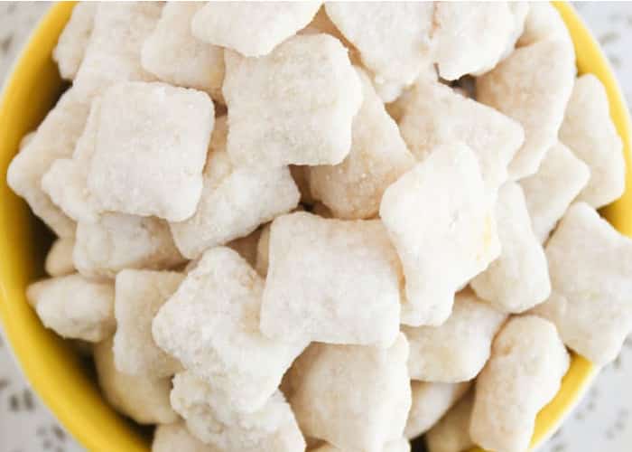 A close up view looking down on lemon chex mix in a yellow bowl