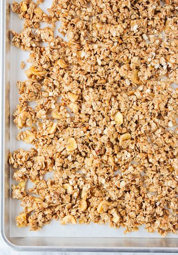 laying unbaked granola on a baking sheet