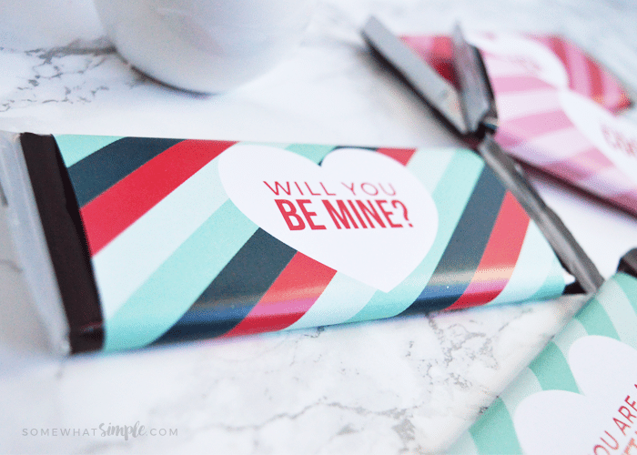 A Hershey candy bar wrapped in this Valentine candy bar wrapper printable that says Will you be mine?