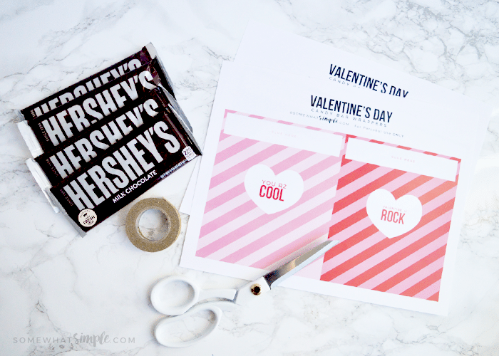 Four Hershey bars, tape, scissors and these free candy bar wrapper printable on a counter