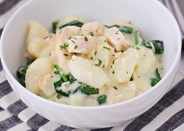 This cheesy chicken spinach gnocchi is a simple and easy dinner that's ready in less than thirty minutes! It's so delicious and the kids will love it too!