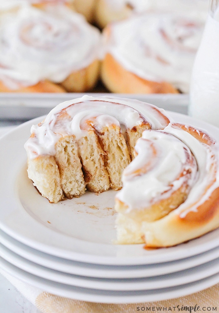 a homemade Cinnamon Roll that has been cut in half and topped with a cream cheese icing