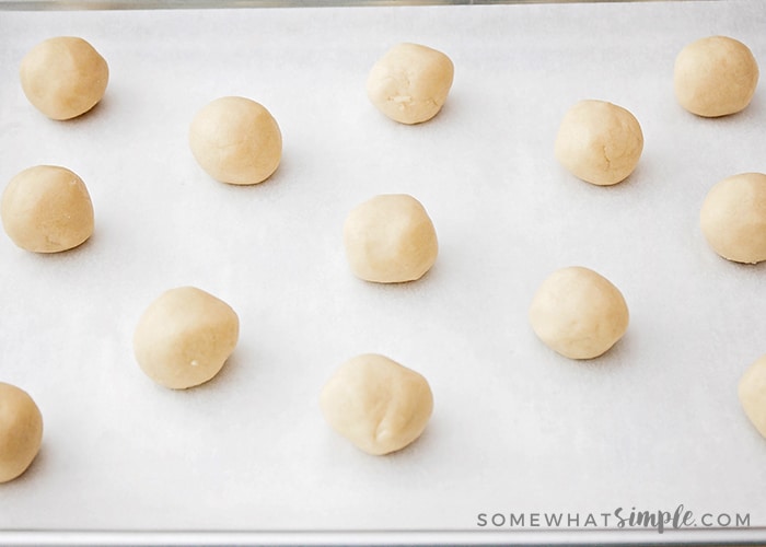 sugar cookie dough rolled into balls on a baking sheet