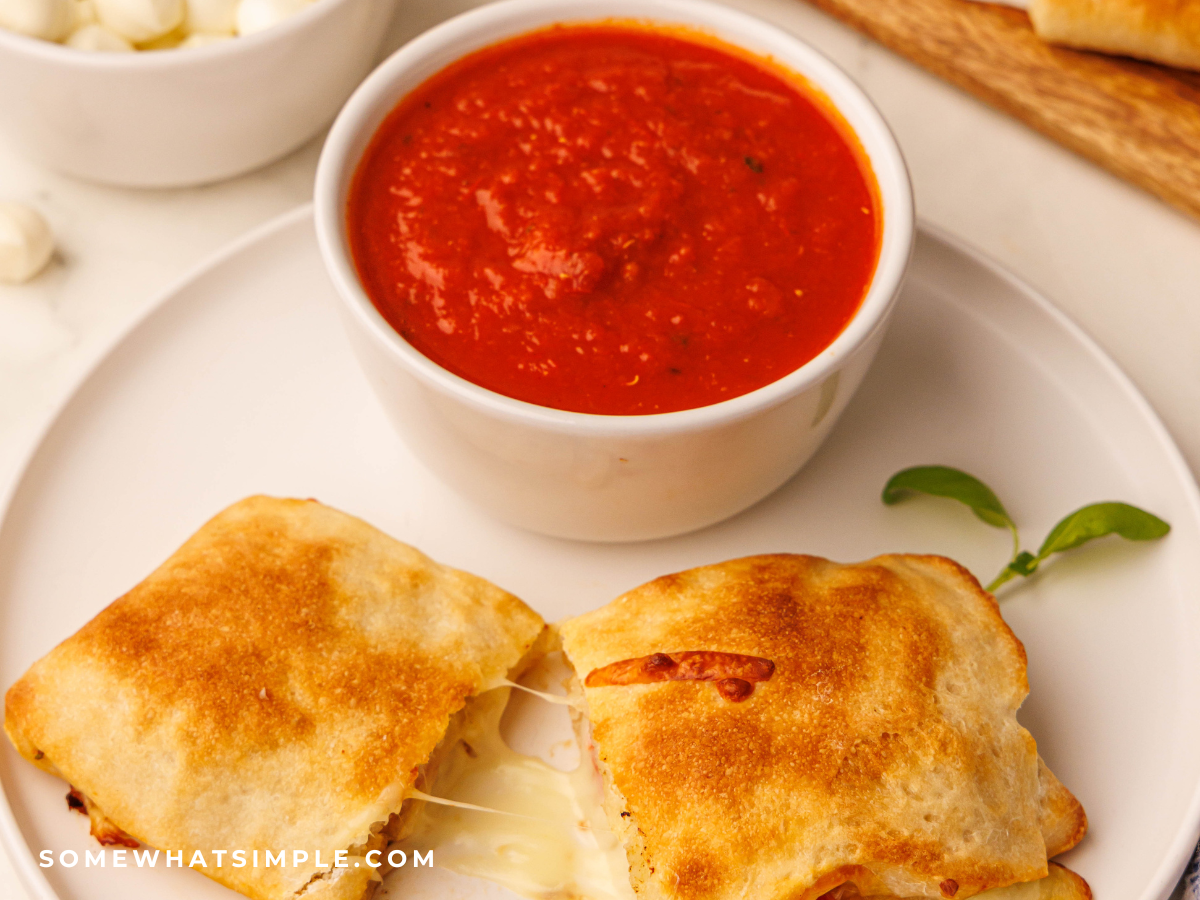 Caprese Calzones next to a dipping bowl of marinar sauce