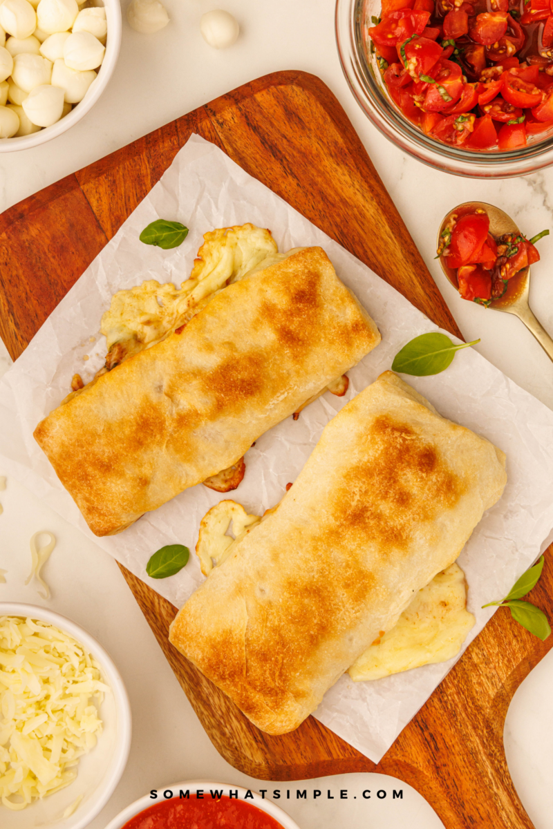 long image of Caprese Calzones on a wood cutting board