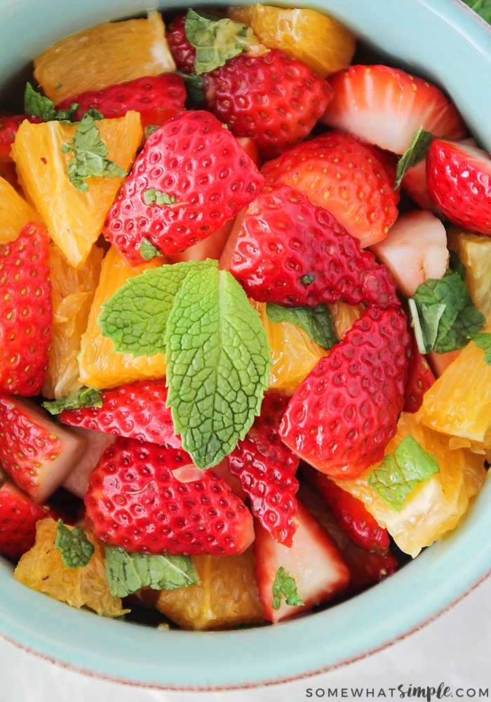 looking down on a light blue bowl of Strawberry Orange Mint Salad