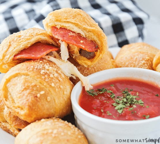 close up of pizza rolls plated with some dipping sauce