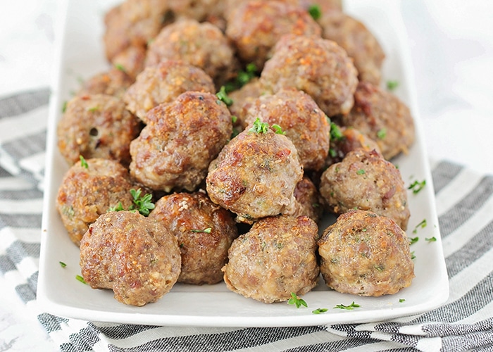 a white tray of homemade meatballs topped with parsley made using this easy recipe