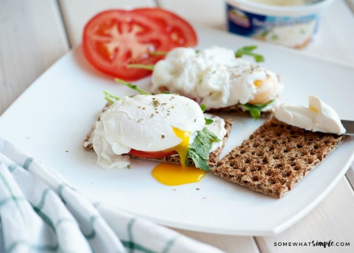 three poached eggs on a toasted piece of bread and slices of tomato