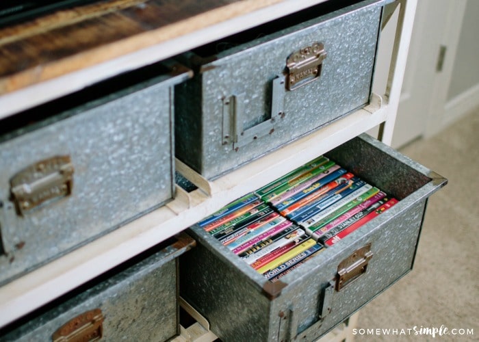 metal bins on a shelf. One is pulled out showing movies neatly organized inside