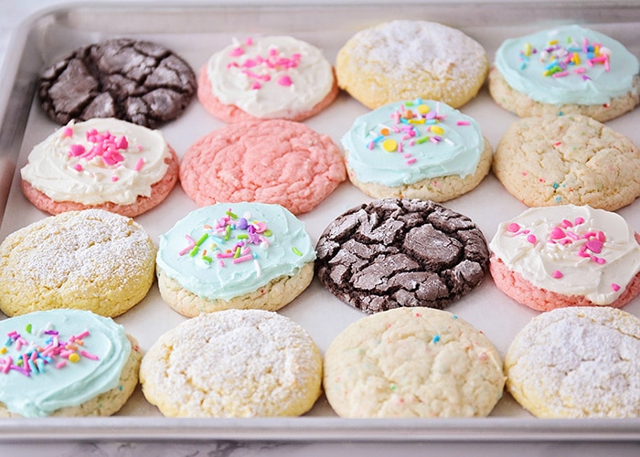 a baking sheet filled with different colored cookies and frosting