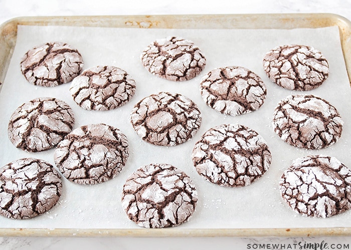 chocolate cake mix cookies on a baking sheet dusted in powdered sugar