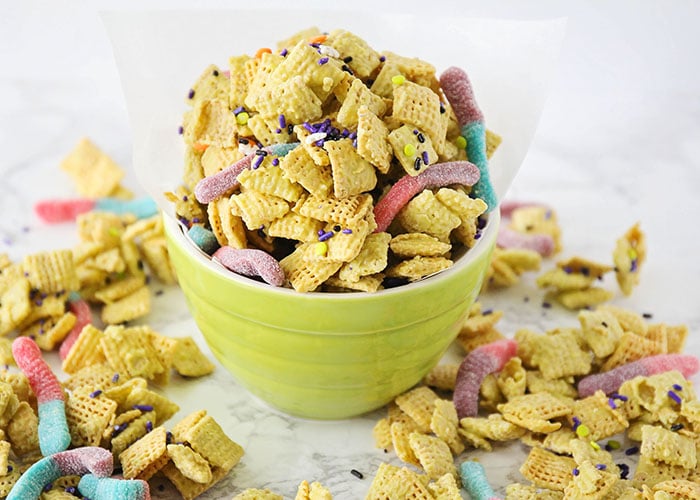 a bowl of zombie bait chex mix with sour gummy worms