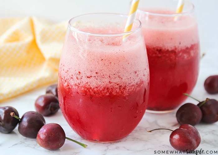 two glasses filled with a frozen cherry lemonade slush