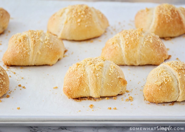 a baking sheet filled with baked chicken crescent roll ups that are golden brown and flaky 