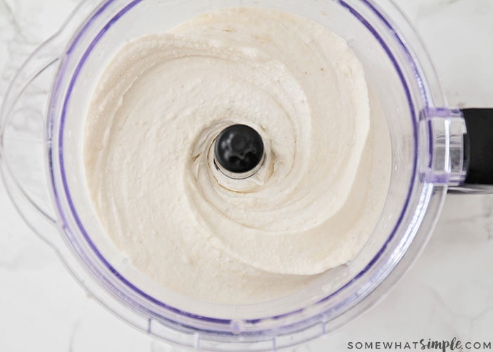 a food processor filled with frozen bananas that were blended with milk to form a creamy mixture