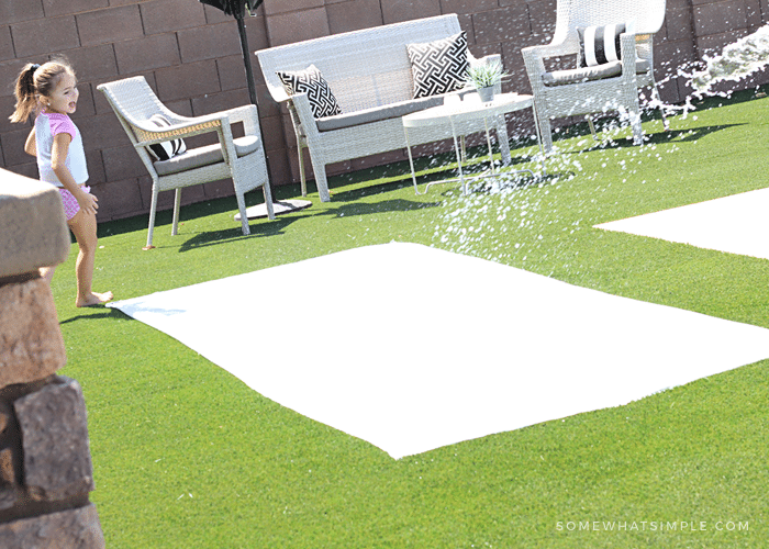 a little girl getting ready to slide on a homemade slip and slide