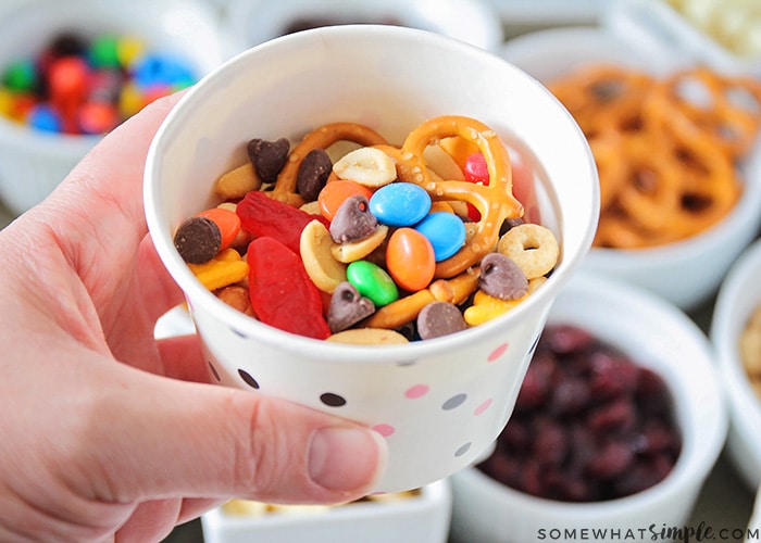 a cup full of trail mix with both salty and sweet items that was made from this easy trail mix bar idea