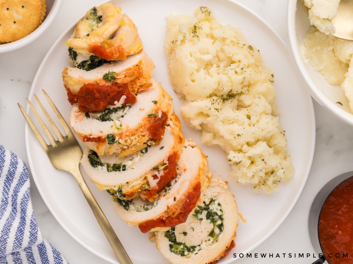 Stuffed chicken parmesan sliced on a white plate