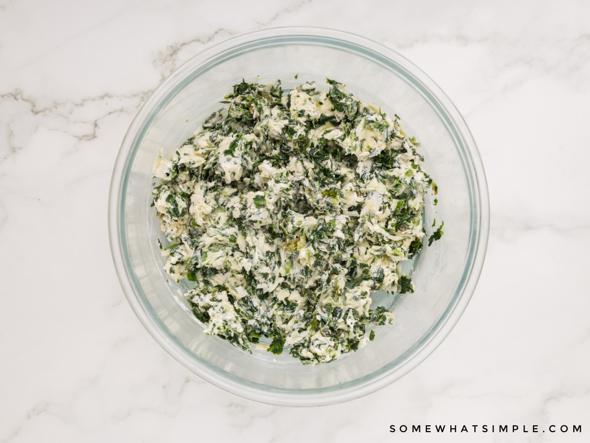 bowl of cream cheese and spinach mixed otgether