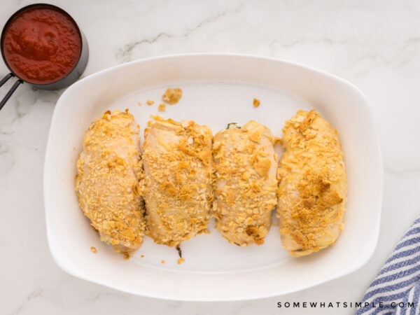 baked stuffed chicken parmesan still in the baking dish