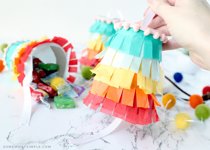 adding ribbon to the bottom of a pinata