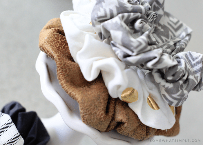 a brown, white and grey scrunchie stacked on top of each other