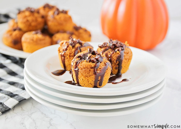 3 soft pumpkin cookie bites on a plate with chocolate drizzled over the top