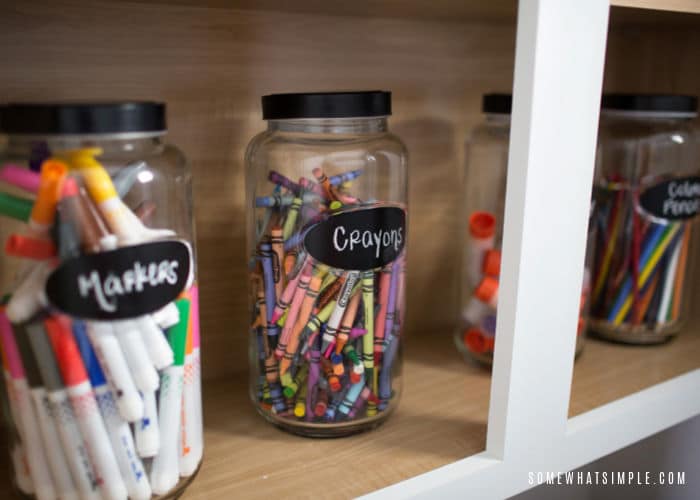 glass jars with crayons and markers that has a label on the jar noting what's inside