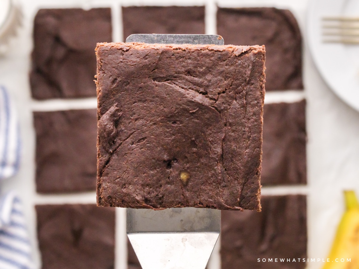 1 square protein brownie on a spatula above the pan of brownies