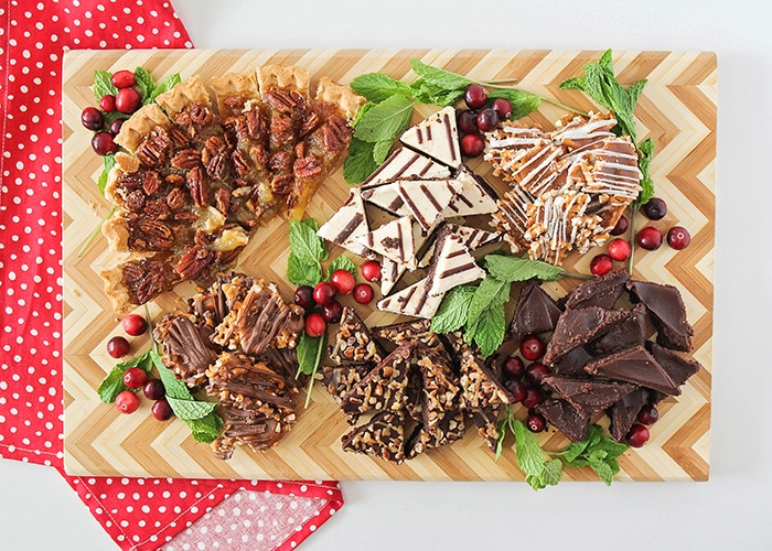 looking down on a wooden Christmas dessert board filled with treats