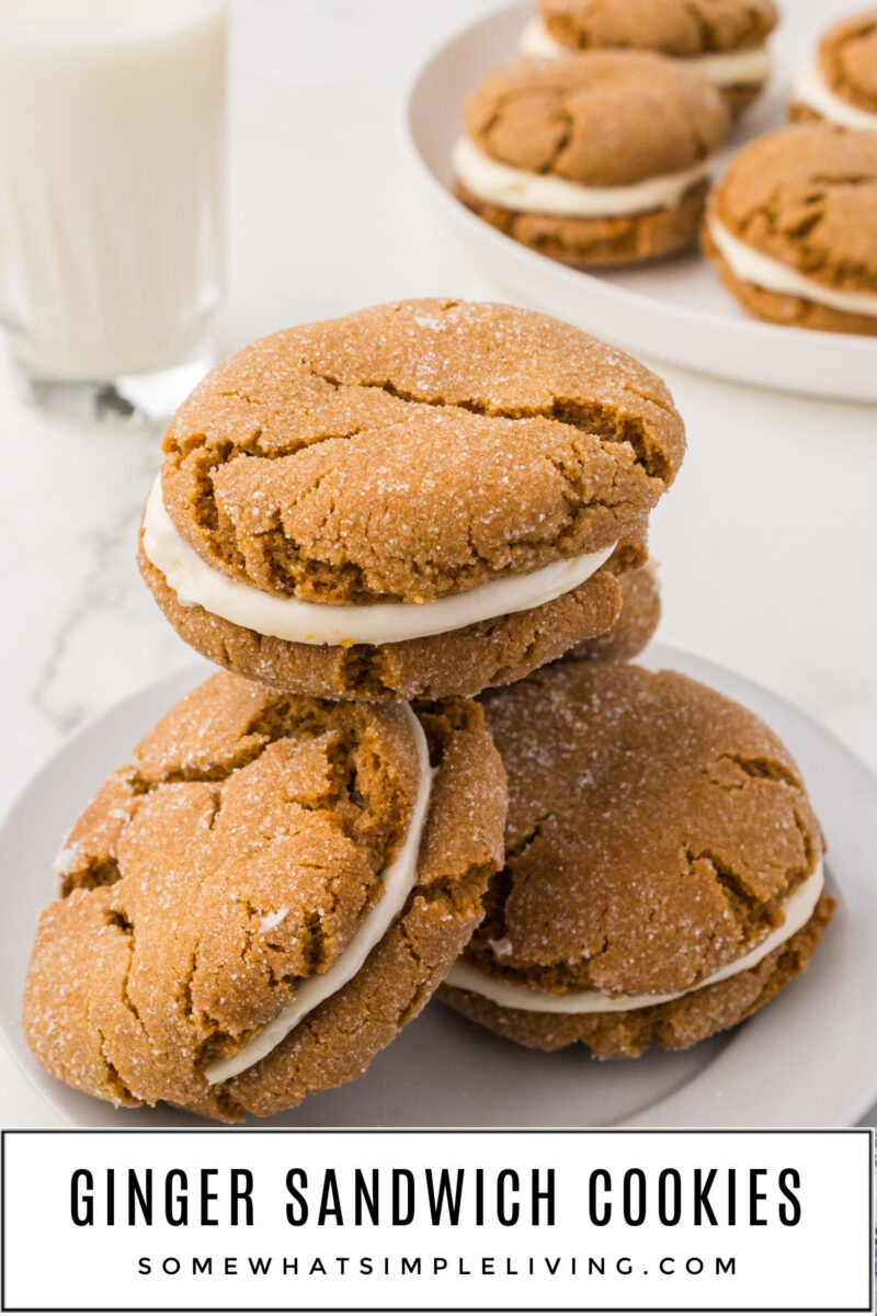 ginger sandwich cookies stacked on top of each other with a glass of milk in the background