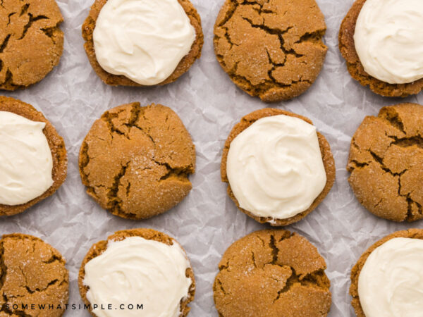 adding frosting onto ginger sandwich cookies