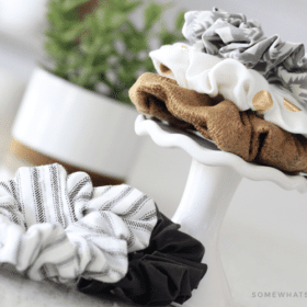 the DIY hair scrunchies stacked on top of each other on a small stand with two more scrunchies lying next to the stand on a counter