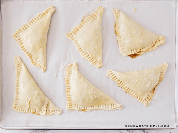 Raw Apple Turnovers on a baking sheet getting ready to go into the oven